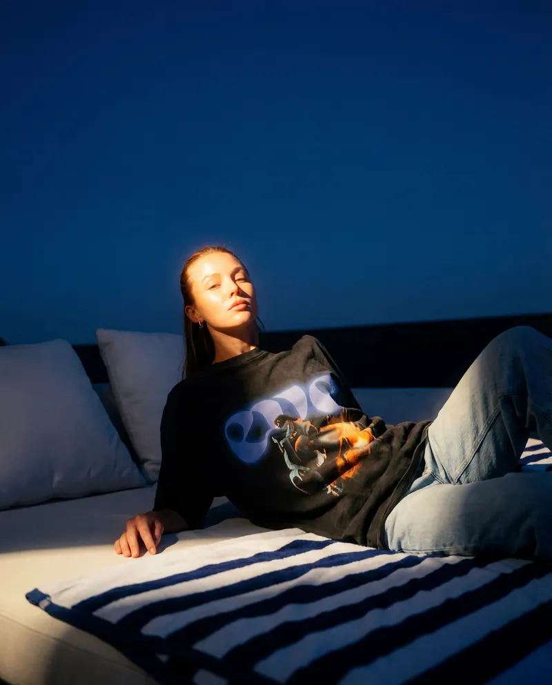 Woman at dusk wearing an EVE logo t-shirt — the brand beyond the ride